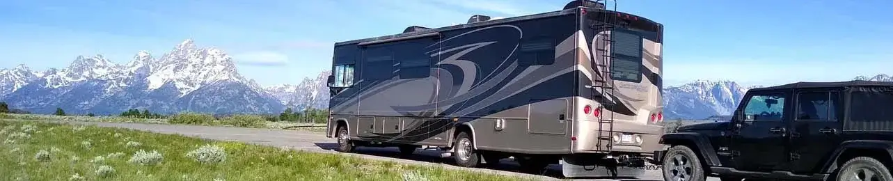 RV and SUV with mountain backdrop