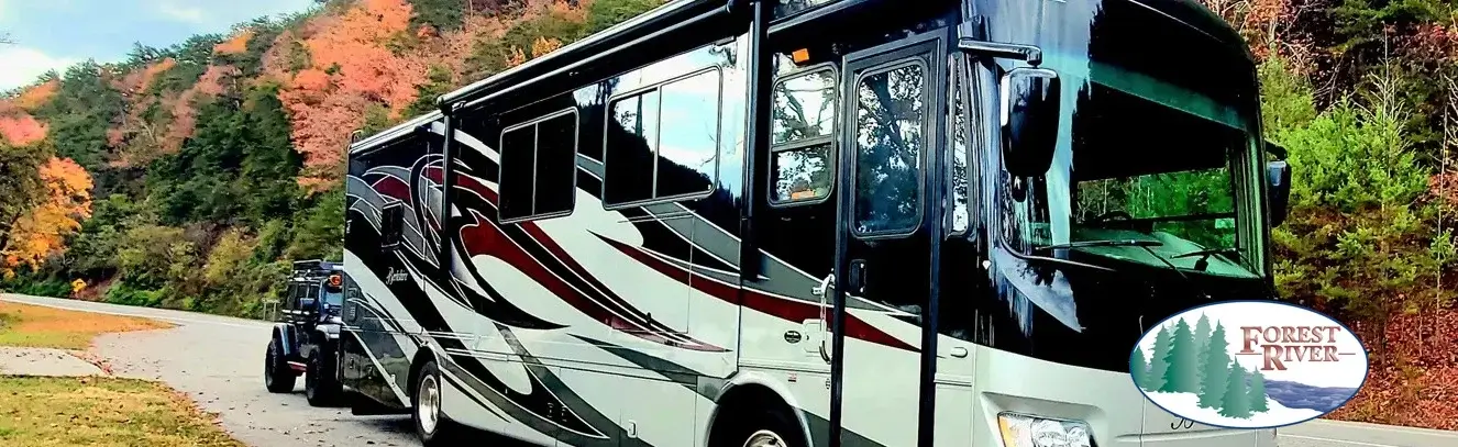 RV on a road with autumn trees